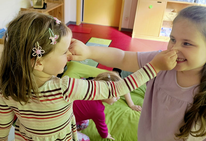 Zwei Kinder fassen sich gegenseitig an die Nase