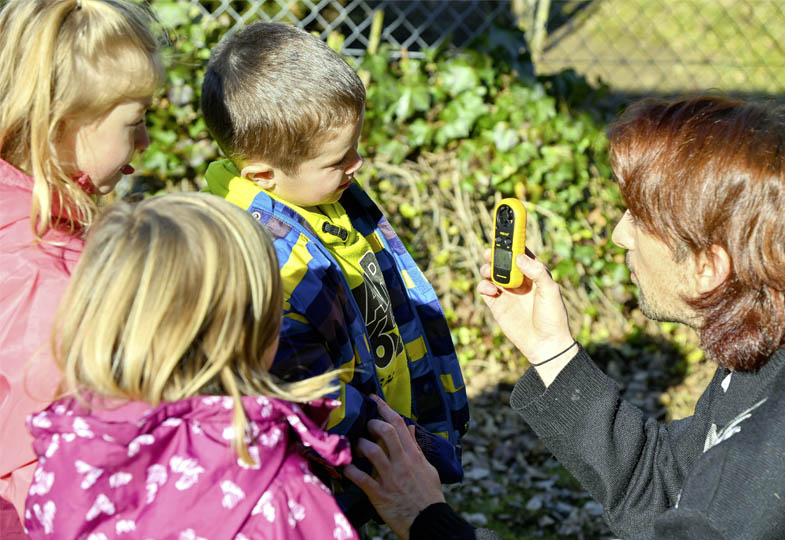 Kinder mit einer erwachsenen Person im Garten