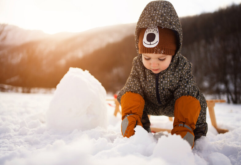 Kleiner Junge baut einen Schneemann